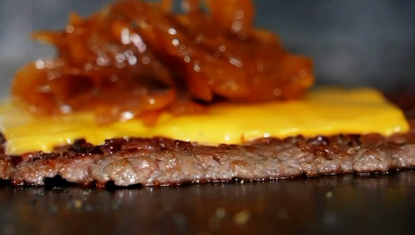 Cheddar fondu et oignons sur le steak, encore sur la plaque